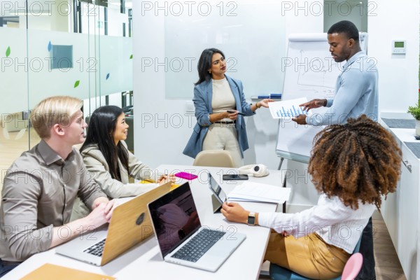 Business professionals collaborating on data analysis, discussing charts and growth strategies during a productive meeting in a contemporary office
