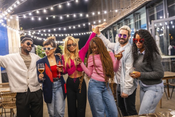 Modern multi-ethnic young people celebrating party outside a bar at night