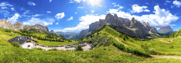 Breathtaking panorama of the dolomites in summer, showcasing lush green valleys, rugged peaks, and a clear blue sky, creating a stunning alpine landscape
