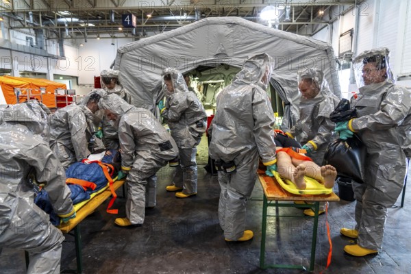 Decontamination of injured persons after an assumed accident involving hazardous substances, fire brigade and aid organisations practise setting up and operating a decontamination station, injured persons are sighted and then washed in a special shower tent to remove possible hazardous substances and chemicals in order to avoid further injuries, the emergency services wear special, ventilated protective suits, large-scale exercise by the Essen fire brigade