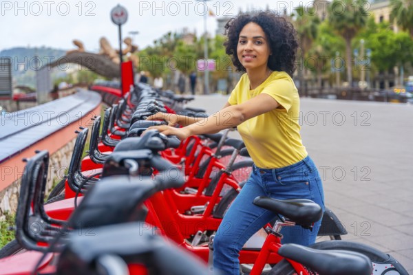 Portrait of a latin young woman smiling at camera while using rental public bike service