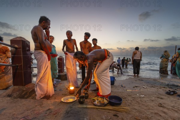 Hindu priest with pilgrims at the fire ritual at Ghat Agni Theertham, Rameswaram, Pamban Island, Tamil Nadu, India, Asia