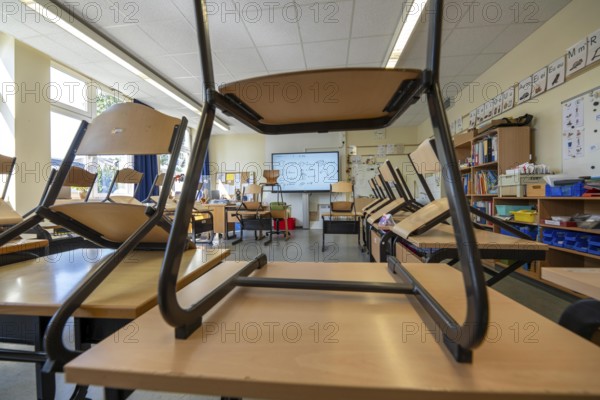 Classroom of a fourth grade, after school, the building is older but in good condition, modern teaching materials, interactive, digital whiteboard