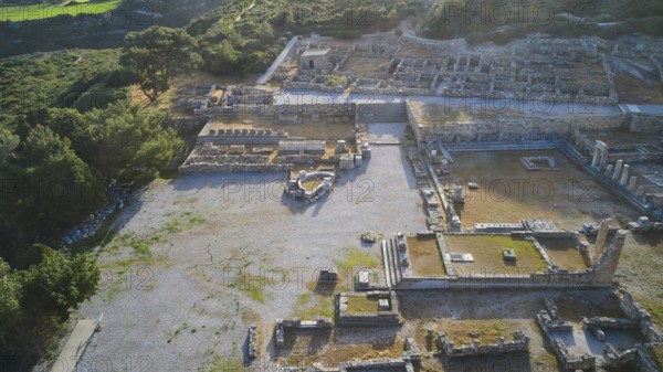 Drone shot, first morning light, backlight, Ancient ruins in an archaeological site, surrounded by nature and trees in daylight with mountains in the background, Kamiros, Archaeological site, Ancient city, Foundation of Doric Greeks, Rhodes, Dodecanese, Greek Islands, Greece, Europe