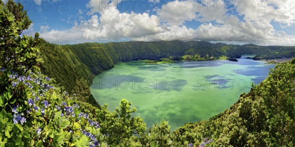 Breathtaking panoramic view of the crater lake Lagoa Azul surrounded by steep rock faces under a clear sky, crater circular hiking trail, Caldeira das Sete Cidades, Sete Cidades, Sao Miguel Island, Azores, Portugal, Europe
