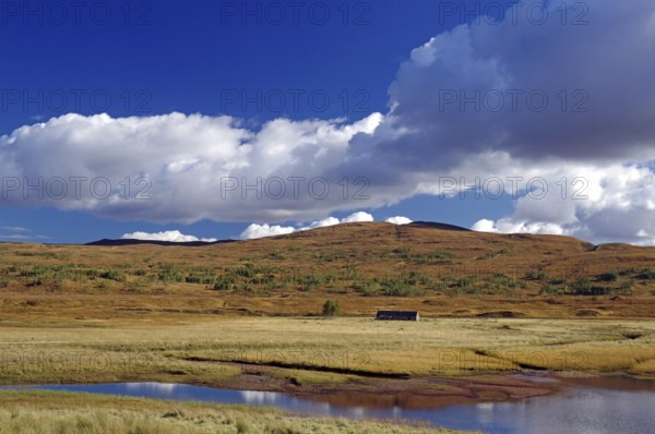 Peaceful lake surrounded by meadows and hills under a blue sky with white clouds, autumn, October, Highlands, railway line Inverness to Kyle of Lochals, Scotland, Great Britain