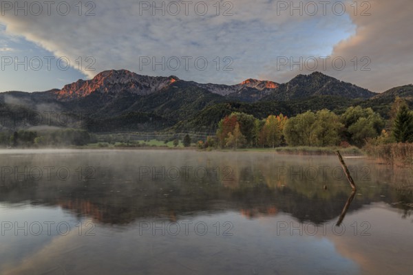 Mountains reflected in lake, morning light, autumn colours, clouds, Lake Kochel, Alpine foothills, Bavaria, Germany, Europe