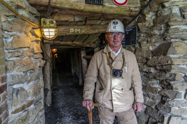 Visitor group at the entrance to the Nachtigallstollen, tour guide, GeoRoute Ruhr, Dünkelberg quarry, in the Muttental valley, here you can see the geology of the region, a thin coal seam is visible, underneath were thicker layers of coal that were mined, Witten, North Rhine-Westphalia, Germany, Europe