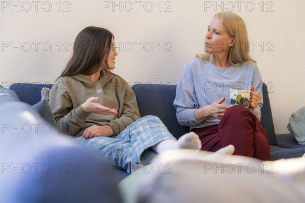 Mother and daughter, teenage, 13 years old, in a confidential conversation, at home