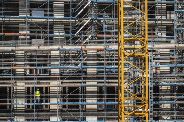 Construction site, at the Cologne Trade Fair Centre, new construction of a high-rise office building, construction cranes, facade of the shell, scaffolding, construction crane, North Rhine-Westphalia, Germany, Europe