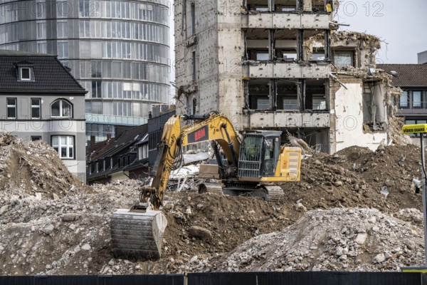Demolition of the former RWE building complex, in the city centre, on the A40 motorway in Essen, excavator working on the piles of rubble, in the background the RWE Tower, North Rhine-Westphalia, Germany, Europe