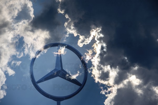 Symbolic image, Dark clouds at Mercedes, Mercedes logo on a building surrounded by dramatic cloud formations and rays of light in the blue sky, Stuttgart-Untertürkheim, Baden-Württemberg, Germany, Europe