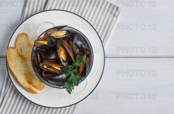 Fresh, Boiled mussels, Black Sea, with white bread, on a white wooden table, no people