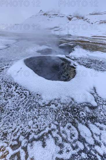 Hot springs and geothermal area in front of a mountain landscape in winter, cloudy mood, Hverir, Namafjall, Myvatn, Iceland, Europe