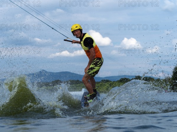 Man jumping with wakeboard, water sports, water skiing and wakepark