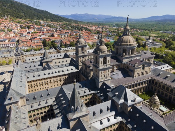 Close-up of a historic monastery with towers, surrounded by a town and mountains in the background, aerial view, Real Sitio de San Lorenzo de El Escorial, Royal Seat of St Lawrence of El Escorial, palace and monastery complex, San Lorenzo de El Escorial, Madrid, Spain, UNESCO World Heritage Site, Europe