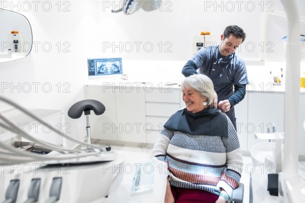 Dentist is preparing a smiling senior woman for a dental checkup in a modern and bright dental clinic