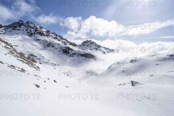 Atmospheric clouds in a wintry mountain landscape, ascent to Porta d'Es-cha, Bündner Haute Route ski tour, Albula Alps, Rhaetian Alps, Grisons, Eastern Switzerland, Switzerland, Europe