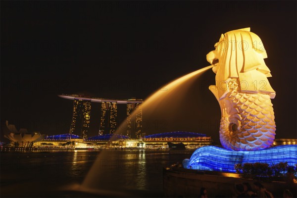 SINGAPORE, JANUARY 1, 2014: Night view of Singapore Merlion at Marina Bay and Marina Bay Sand complex. Merlion is a well-known tourist icon, mascot and national personification of Singapore