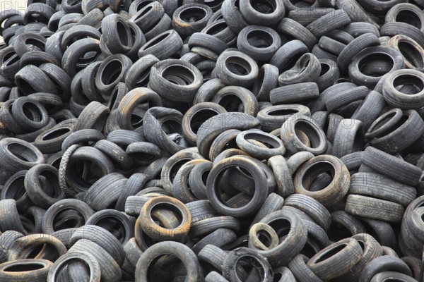 Old car tyres lie on stockpiles for recycling