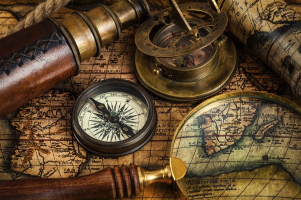 Travel geography navigation concept background, old vintage retro compass, sundial, magnifying glass and spyglass on ancient world map