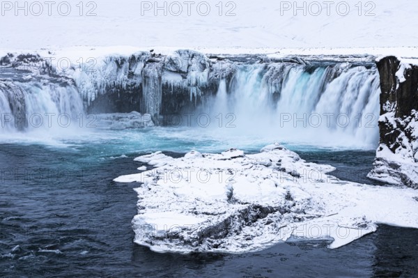 Ice layer in the river Skialfandaljot, behind it the waterfall Godafoss, Northern Iceland Eyestra, Iceland, Europe