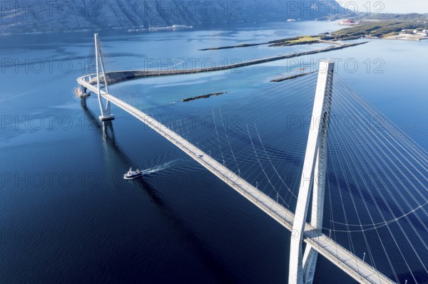Aerial view of Helgeland bridge, connecting Sandnessjøen with the norwegian mainland, fishing boat passing by, Norway, Europe