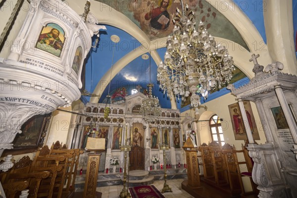 A magnificently decorated church interior with chandeliers, an ornate altar and colourful icons, Platia and Church of Issodia Theotokou, Nikia, Nisyros, Dodecanese, Greek Islands, Greece, Europe