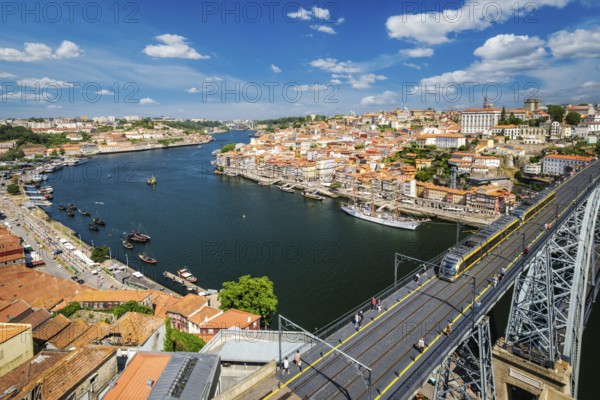 View of Porto city and Douro river with moored sailing ship and Dom Luis bridge I from famous tourist viewpoint Miradouro da Serra do Pilar on sunset. Porto, Vila Nova de Gaia, Portugal, Europe