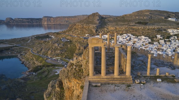 Drone shot, first morning light, Lindos, Acropolis of Lindos, Temple of Athena Lindia, Acropolis with ancient columns in front of a sunlit sea and sky, Archaeological site, Lindos, Rhodes, Dodecanese, Greek Islands, Greece, Europe