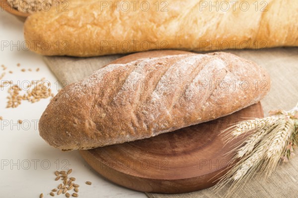 Different kinds of fresh baked bread on a white wooden background. side view, close up, selective focus