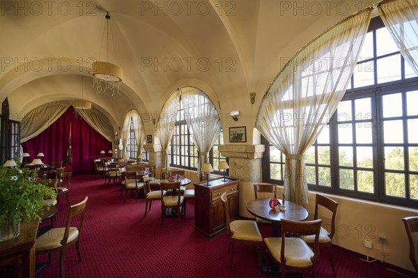 Elegant interior of a restaurant with red carpets, curtains, arched windows and table groups, Elafos Hotel, Profitis Ilias, Rhodes, Dodecanese, Greek Islands, Greece, Europe
