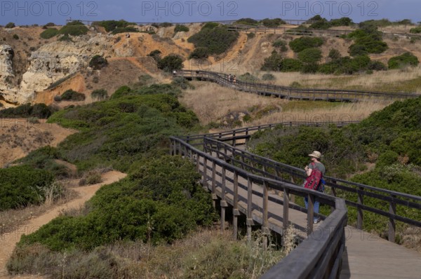 Woman on boardwalk, coastal hiking trail, wooden boardwalk, boardwalk, Ponta da Piedade, Lagos, cliffs, Atlantic Ocean, Algarve, Portugal, Europe
