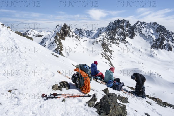 Ski tourers taking a break at the summit, on the Graubünden Haute Route, Scalettahorn, Snow-covered mountains, Winter in the Albula Alps, Graubünden, Switzerland, Europe