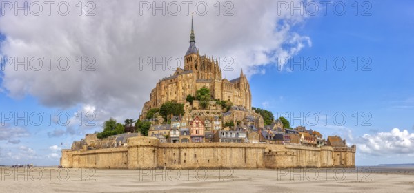 Impressive abbey on an island in the middle of a vast sandy landscape under a blue sky, Le Mont-Saint-Michel