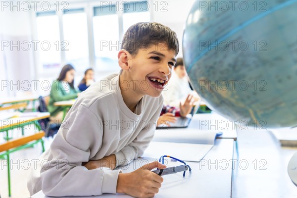 Happy student with down syndrome smiling while exploring a globe in geography class, showcasing inclusive education and learning