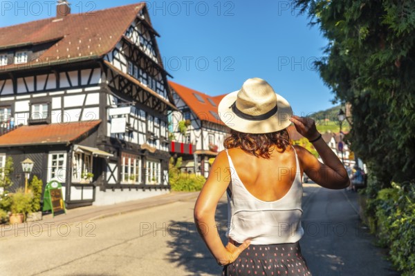 A female tourist from behind in the medieval mountain village of Sasbachwalden, Black Forest, Germany, Europe