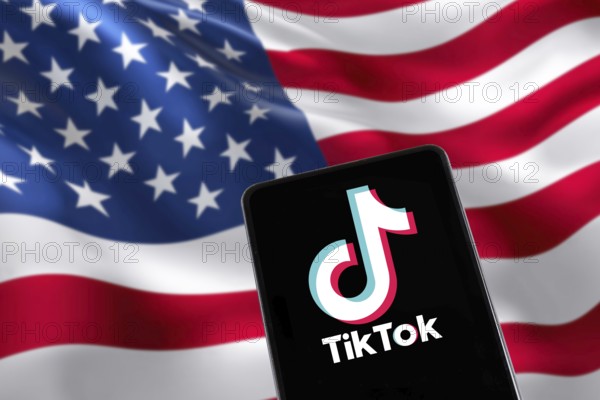 TikTok logo from China with USA United States of America flag social media on a mobile phone in Stuttgart, Germany, Europe