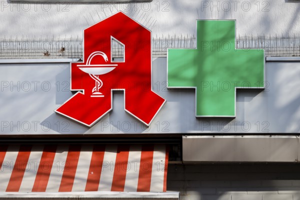 Pharmacies are systemically relevant in the corona crisis, red logo and green cross on the facade of a pharmacy, Essen, Ruhr area, North Rhine-Westphalia, Germany, Europe