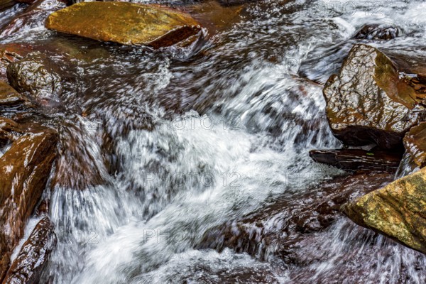 Small stream with its waters running over rocks in Minas Gerais, Minas Gerais, Brazil, South America