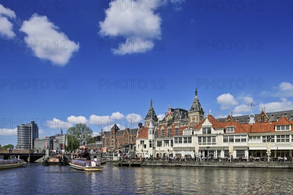 Centraal Station, Central Station, in the foreground boat moorings for canal cruises, Amsterdam, Netherlands