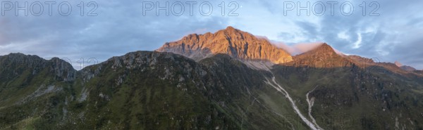 Panorama, rocky mountain peak Porze and green mountain landscape with river valley at sunrise, alpenglow, Carnic High Trail, Carnic Alps, Carinthia, Austria, Europe