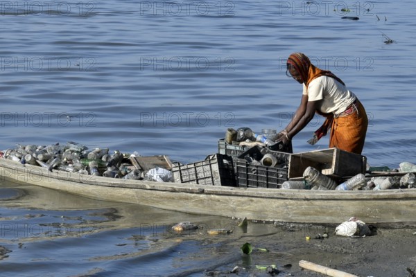 A women rag picker collecting plastic bottle and other plastic materials in a boat from the bank of Brahmaputra River in Guwahati, Assam, India on Monday, October 29, 2018