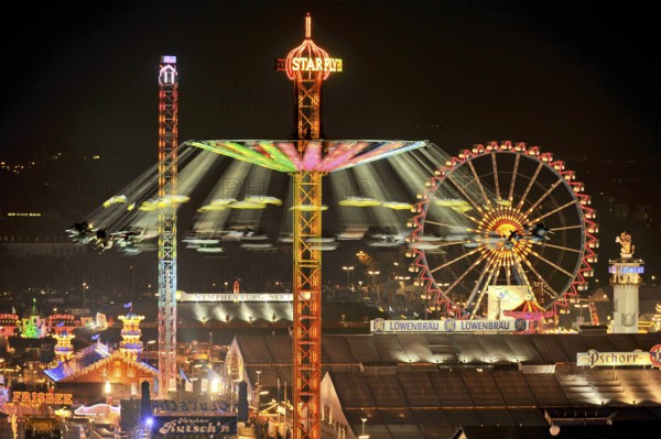 View over the Wies'n at night with illuminated carousel, Ferris wheel, stalls, beer tents and rides, Oktoberfest, Wiesn, Munich, Upper Bavaria, Bavaria, Germany, Europe