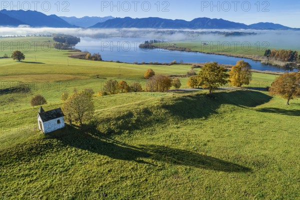 Aerial view of a small chapel in front of a lake, mountain landscape, autumn, sunny, Riegsee, Alpine foothills, Upper Bavaria, Bavaria, Germany, Europe