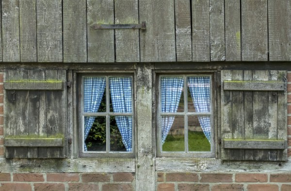 Old wooden window with blue curtains and weathered shutters, Münsterland, North Rhine-Westphalia, Germany, Europe