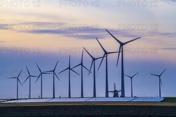 Windmill Poldermolen De Goliath stands between the high-tech wind turbines in Eemshaven, historic windmill from around 1882, rebuilt and reconstructed several times, Westereems wind farm, solar farm on sea dike, Slaperdijk, a good 5 kilometres long, Netherlands