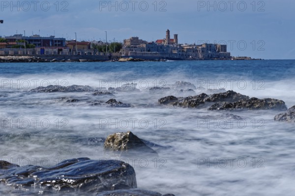 Rocky beach and gentle waves in the Mediterranean near Giovinazzo in the province of Bari. Giovinazzo, Apulia, Southern Italy, Southern Europe