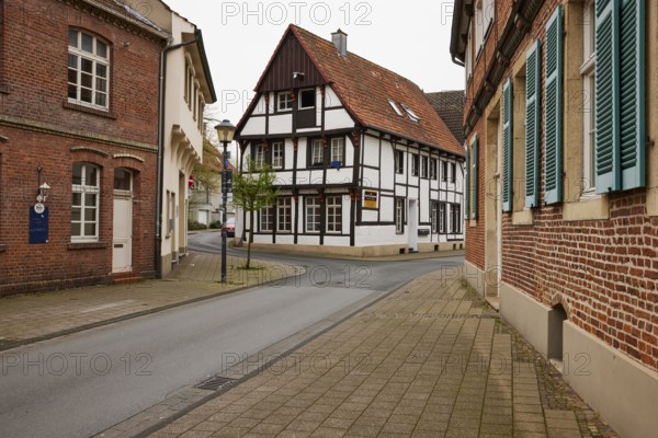 Historic brick houses with white windows and shutters and a small half-timbered house in Warendorf, Warendorf district, North Rhine-Westphalia, Germany, Europe