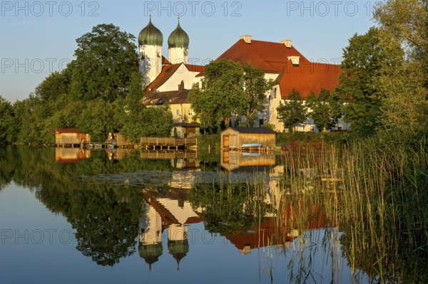 Romanesque Benedictine Abbey Seeon Monastery, monastery church St. Lambert with reflection in the monastery lake, calm smooth water in the evening light at sunset, Seeon-Seebruck, Chiemgau, Upper Bavaria, Bavaria, Germany, Europe